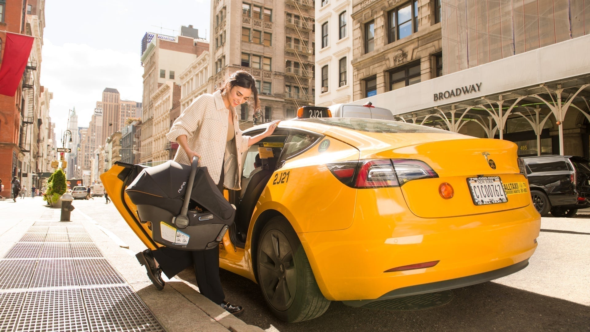 Women entering a cab with Nuna PIPA Urbn infant car seat