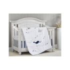 White & Navy Whale Print Quilt Draped Over Crib - Nursery Room View | Bambi Baby