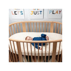 Naturepedic Organic Cotton Oval Crib Mattress with Baby in Natural Wood Stokke Sleepi - Nursery Lifestyle | Bambi Baby